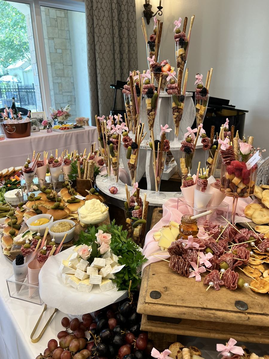 Abundant grazing table layered with fruit, cheese and skewers