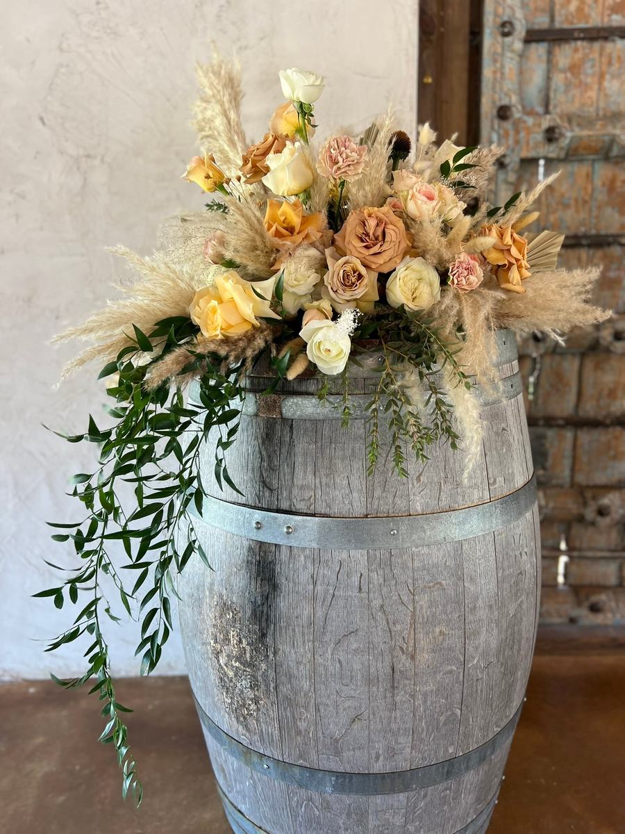 Peach and cream arrangement on a wine barrel