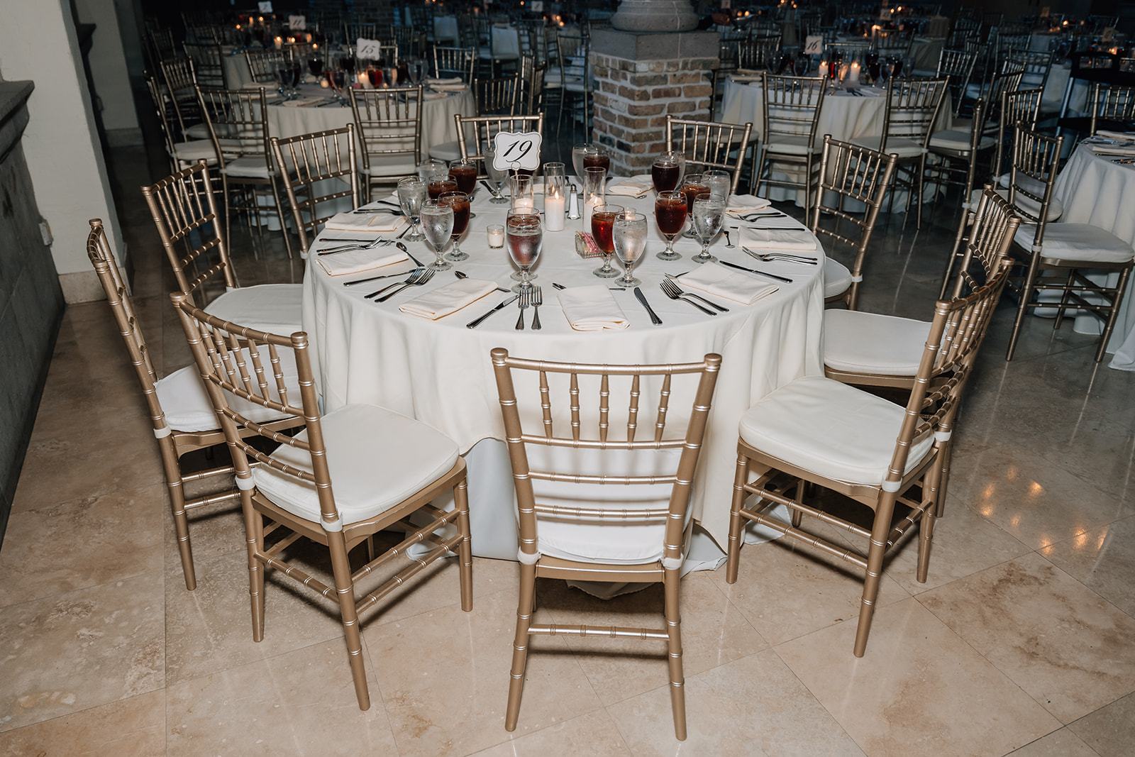 Candlelit round tables in a stone reception hall