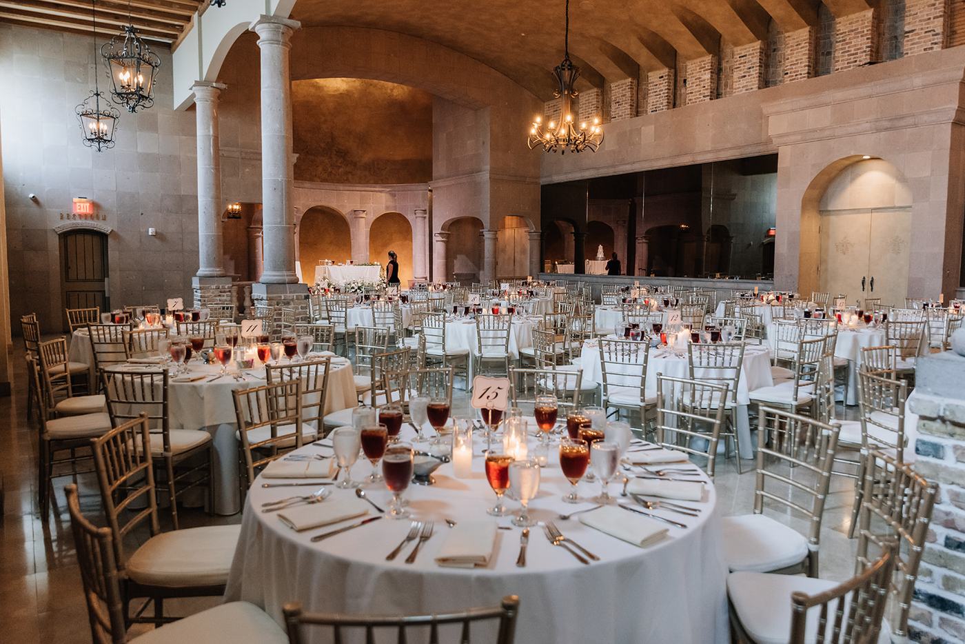 Candlelit round tables set for a reception